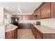 Modern kitchen featuring wood cabinets, tile floors, a built-in microwave, and essential appliances at 22196 W Tonto St, Buckeye, AZ 85326