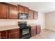 A kitchen with dark wood cabinets and modern black appliances at 22196 W Tonto St, Buckeye, AZ 85326