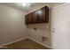 A functional laundry room offering cabinets, tile flooring, and easy access to hookups at 22196 W Tonto St, Buckeye, AZ 85326