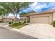 Attractive single-story home showcasing a lush green lawn, mature trees, tiled roof, and an attached two-car garage at 23756 S Vacation Way, Sun Lakes, AZ 85248