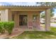 Charming covered patio with lawn and two red striped lounge chairs for relaxing and enjoying the outdoors at 23756 S Vacation Way, Sun Lakes, AZ 85248