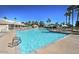 Large, inviting community swimming pool with plenty of lounge chairs, umbrellas, and lush landscaping at 23756 S Vacation Way, Sun Lakes, AZ 85248