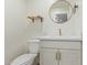 Powder room featuring a white vanity, round mirror, gold faucet, and modern toilet at 2402 E Cinnabar Ave, Phoenix, AZ 85028