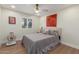 A cozy bedroom with tile floors, stylish bedding, a ceiling fan, and a bright window at 2402 E Cinnabar Ave, Phoenix, AZ 85028