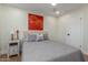 This bedroom offers tile floors, a ceiling fan, a bright window, and a comfortable bed at 2402 E Cinnabar Ave, Phoenix, AZ 85028