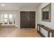 Inviting foyer featuring tiled floors, a dark wood entry door, a rustic console table, and a mirror at 2402 E Cinnabar Ave, Phoenix, AZ 85028