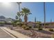 A charming single story home offers a welcoming facade with desert landscaping, trees, and a walkway to the front door at 2402 E Cinnabar Ave, Phoenix, AZ 85028