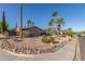 Charming single-story home featuring desert landscaping with palm trees, gravel, and rock border at 2402 E Cinnabar Ave, Phoenix, AZ 85028