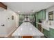 Kitchen showcases custom green cabinets, stainless appliances, a white backsplash, and a large center island at 2402 E Cinnabar Ave, Phoenix, AZ 85028