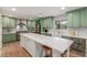 Bright kitchen features custom green cabinets, stainless appliances, a white backsplash, and an oversized center island at 2402 E Cinnabar Ave, Phoenix, AZ 85028