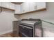 Laundry room boasting modern appliances and ample white cabinet storage above the machines at 2402 E Cinnabar Ave, Phoenix, AZ 85028