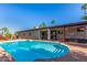The backyard includes a sparkling blue pool, an outdoor seating area, and a well-maintained patio for leisure at 2402 E Cinnabar Ave, Phoenix, AZ 85028
