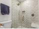Glass-enclosed shower featuring decorative tile, a shower bench, and gold hardware at 2402 E Cinnabar Ave, Phoenix, AZ 85028
