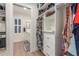 Custom walk-in closet featuring built-in shelving and drawers, and an open view to an ensuite bathroom at 2402 E Cinnabar Ave, Phoenix, AZ 85028