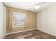 This bedroom features hardwood floors, a ceiling fan, and a window that offers plenty of natural light at 2422 W Acoma Dr, Phoenix, AZ 85023