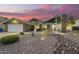 Charming home featuring desert landscaping, a chimney, and a two-car garage against a stunning pink sky at dusk at 2422 W Acoma Dr, Phoenix, AZ 85023
