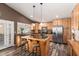 Well-lit kitchen with wooden cabinets, stainless steel appliances, and a central island with barstool seating at 2422 W Acoma Dr, Phoenix, AZ 85023