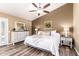 This main bedroom boasts wood-look floors, white furniture, and a ceiling fan for a comfortable and stylish space at 2422 W Acoma Dr, Phoenix, AZ 85023