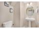 Powder bathroom with a pedestal sink, round mirror, and neutral wall paint at 2631 S Sulley Dr # 104, Gilbert, AZ 85295