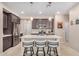 Modern kitchen featuring an island with seating, stainless steel appliances, and dark wood cabinetry at 2631 S Sulley Dr # 104, Gilbert, AZ 85295