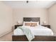 Bedroom with a wooden bed frame, a white quilt, end tables, and lamps at 2631 S Sulley Dr # 104, Gilbert, AZ 85295