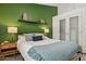 Bright bedroom featuring a queen bed, modern furniture, and a vibrant green accent wall at 28814 N 45Th St, Cave Creek, AZ 85331