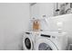 Clean laundry area features modern appliances, storage cabinets, and white walls at 28814 N 45Th St, Cave Creek, AZ 85331