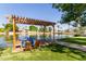 Scenic view of the community lake with a wooden pergola, charming boats, and serene water reflecting the clear sky at 3109 N Meadow Dr, Avondale, AZ 85392