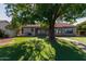 Charming home with a well-maintained front yard, lush lawn, and mature trees providing shade and curb appeal at 3109 N Meadow Dr, Avondale, AZ 85392