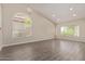 Spacious living room with gray wood floors, neutral walls, and vaulted ceilings at 3109 N Meadow Dr, Avondale, AZ 85392