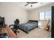 Bedroom with guitar, computer desk and chair next to a bed with ceiling fan and window at 3247 E Creosote Ln, Gilbert, AZ 85298