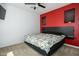 Cozy carpeted bedroom with floral comforter, red accent wall, and ceiling fan at 3247 E Creosote Ln, Gilbert, AZ 85298