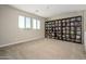 Bright bonus room featuring a large bookcase, plush carpet, and lots of natural light at 3247 E Creosote Ln, Gilbert, AZ 85298