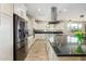 Modern kitchen featuring white cabinetry, stainless steel appliances, and a large island with granite countertops at 3247 E Creosote Ln, Gilbert, AZ 85298