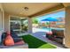 Covered outdoor living space with comfortable seating and a view of the sparkling pool and landscaped yard at 3247 E Creosote Ln, Gilbert, AZ 85298
