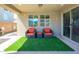 Relaxing covered patio with comfortable seating and artificial grass, ideal for enjoying the outdoors at 3247 E Creosote Ln, Gilbert, AZ 85298
