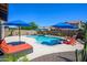 Beautiful backyard featuring a sparkling pool, blue umbrellas, and comfortable lounge chairs at 3247 E Creosote Ln, Gilbert, AZ 85298