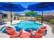 Inviting pool area with colorful Adirondack chairs, umbrellas, and well-maintained landscaping at 3247 E Creosote Ln, Gilbert, AZ 85298
