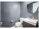Powder room with stylish gray textured wall, decorative mirror, and modern vanity at 3247 E Creosote Ln, Gilbert, AZ 85298
