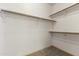 Empty closet with wooden shelves and carpeted flooring offers practical storage at 351 N Danyell Dr, Chandler, AZ 85225