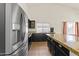 Kitchen features stainless steel refrigerator, and black cabinets with granite countertops at 351 N Danyell Dr, Chandler, AZ 85225