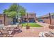 This home's backyard features a covered patio, artificial lawn, and landscaped areas for outdoor enjoyment at 43822 W Baker Dr, Maricopa, AZ 85138