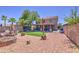 Home's backyard offers a covered patio, artificial lawn, and a well-maintained landscape for outdoor gatherings at 43822 W Baker Dr, Maricopa, AZ 85138