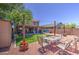 The backyard offers an artificial lawn, a covered patio, and comfortable seating for outdoor enjoyment at 43822 W Baker Dr, Maricopa, AZ 85138