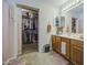 Large bathroom featuring dual sinks, wood cabinets, and access to a closet at 43822 W Baker Dr, Maricopa, AZ 85138