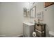Bright bathroom with a gray vanity cabinet, white countertop and a decorative sign on the wall at 43822 W Baker Dr, Maricopa, AZ 85138