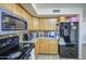 Functional kitchen featuring wood cabinets, granite countertops, and a black refrigerator at 43822 W Baker Dr, Maricopa, AZ 85138