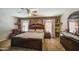 This primary bedroom boasts a luxurious, oversized bed, complementing decor, and a ceiling fan for added comfort at 43822 W Baker Dr, Maricopa, AZ 85138