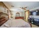 Well-appointed primary bedroom offers a luxurious bed, modern ceiling fan, and a large television for relaxation at 43822 W Baker Dr, Maricopa, AZ 85138