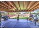 Covered patio features an outdoor kitchen, ceiling fan, and a well-manicured lawn for entertaining at 43822 W Baker Dr, Maricopa, AZ 85138